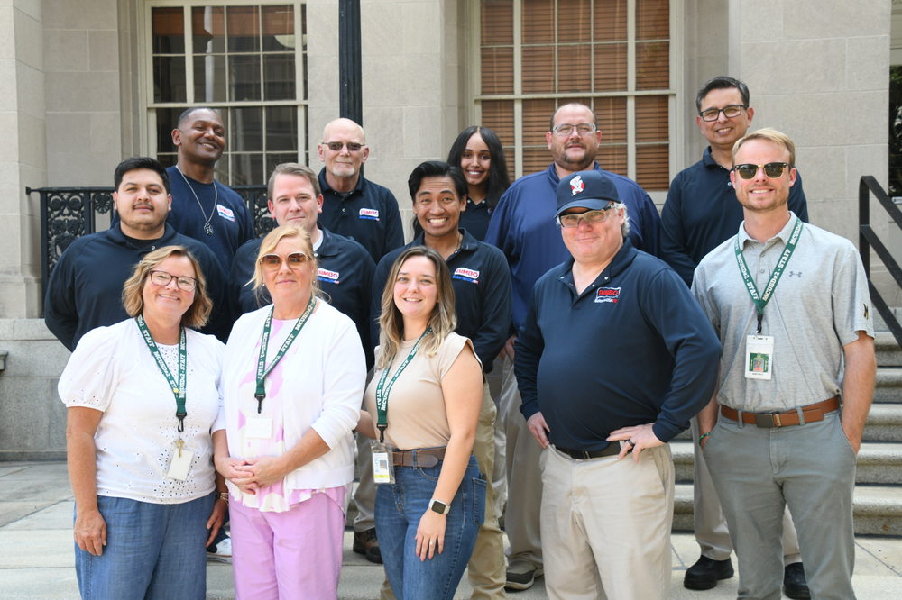 School staff employees pictured with Bimbo Bakery employees who donated backpacks to the schools