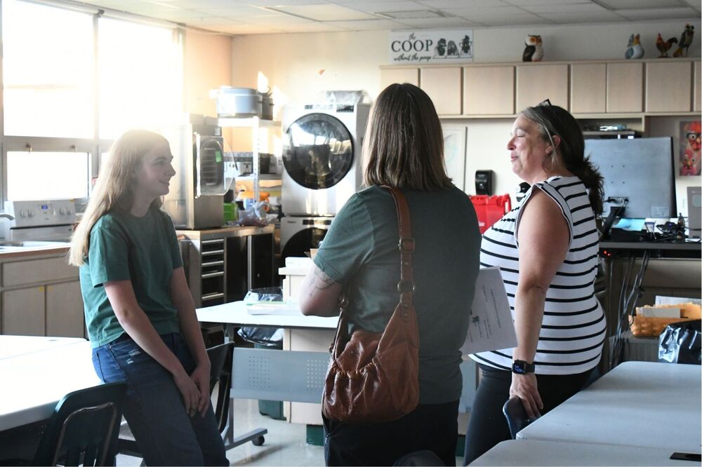 student, parent, and teacher talking at MHS open house