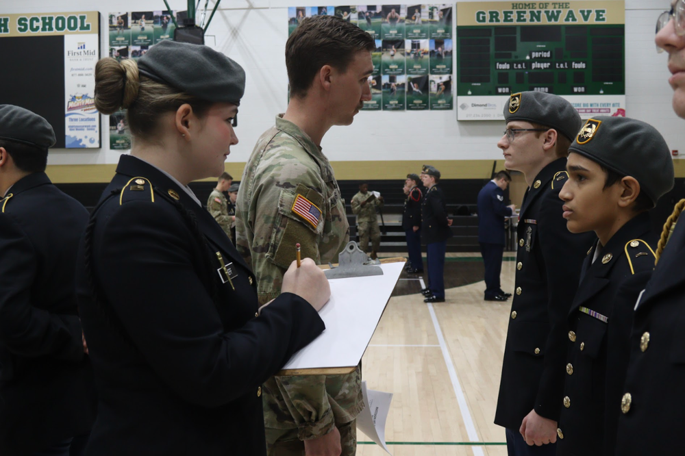 MHS JROTC inspection. Two students are inspecting others. One is holding a clipboard