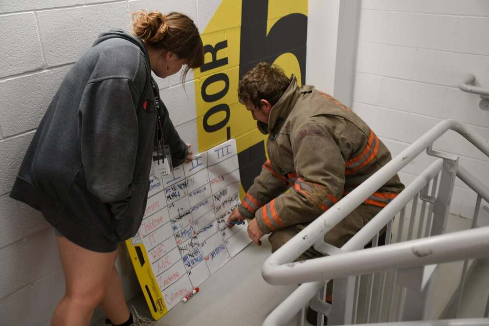 LIFT Stair Climb Challenge. Firefighter doing challenge putting a talley on a chart