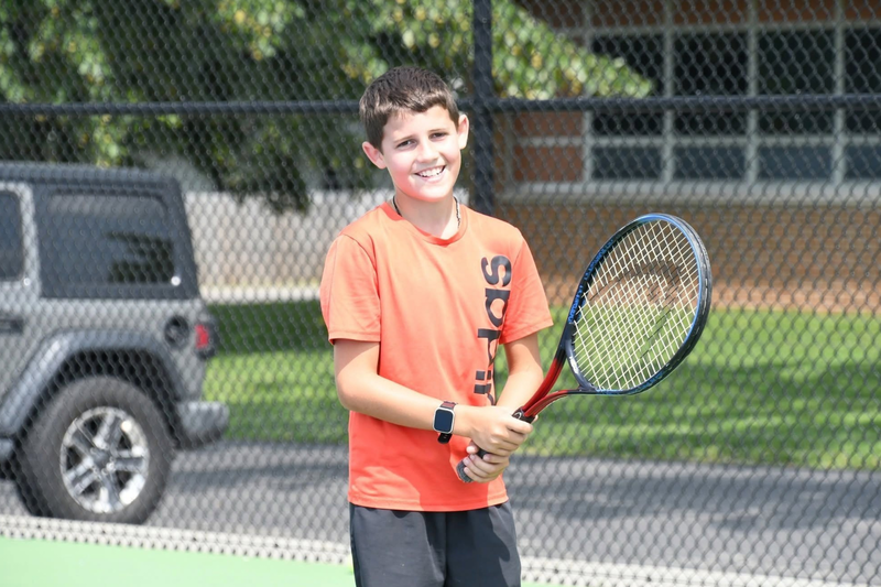 tennis student holding a racket on the court