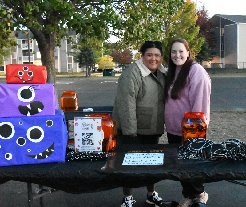 Photo of a table and two staff members at the Williams Trunk or Treat event