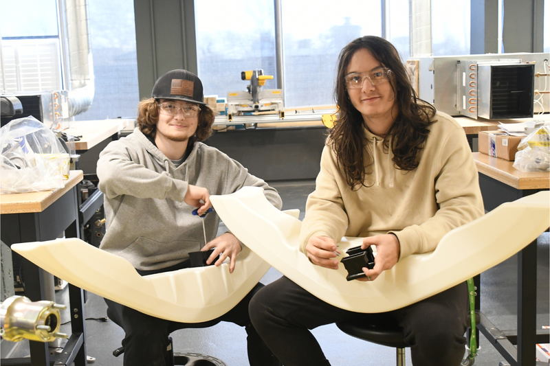 Two LIFT students working on the karts