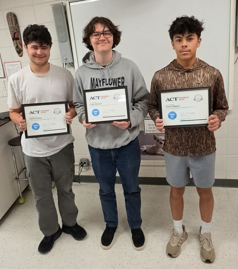 The image shows, from left to right, Dominic Hinton, Logan Deierlein, and Kaelum Nguyen holding certificates awarded for earning  Platinum on their WOrkkeys assessment.