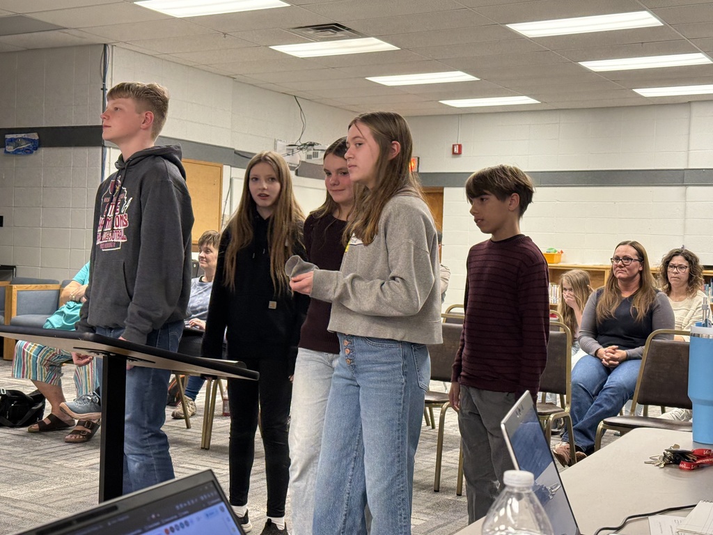 7th graders presenting passion project for the Lion's Point Park project at Board of Education meeting, parents in audience in background
