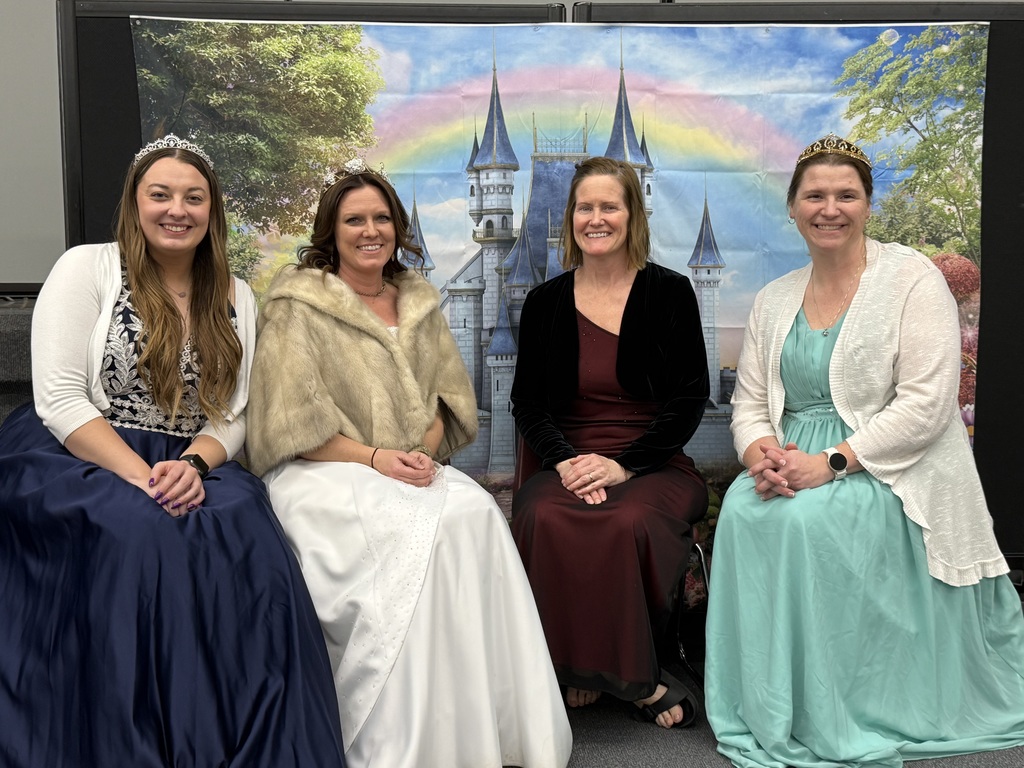 Four teaching staff members from 5K dressed up as queens with castle and rainbow backdrop