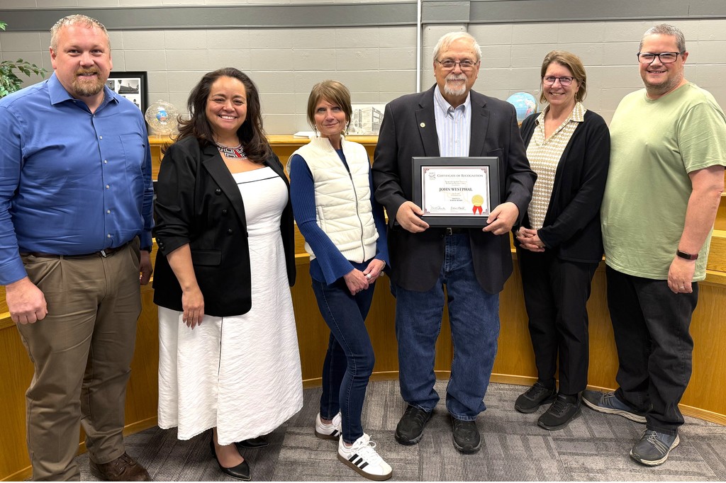 John Westphal Board Member recognition for 30 years of service, Mr. Westphal holding plaque in Board Administration Room within the Early Learning Center at Parkview, surrounded by fellow Board members, his family and presented the plaque by Dan Rossmiller, Executive Director of WASB