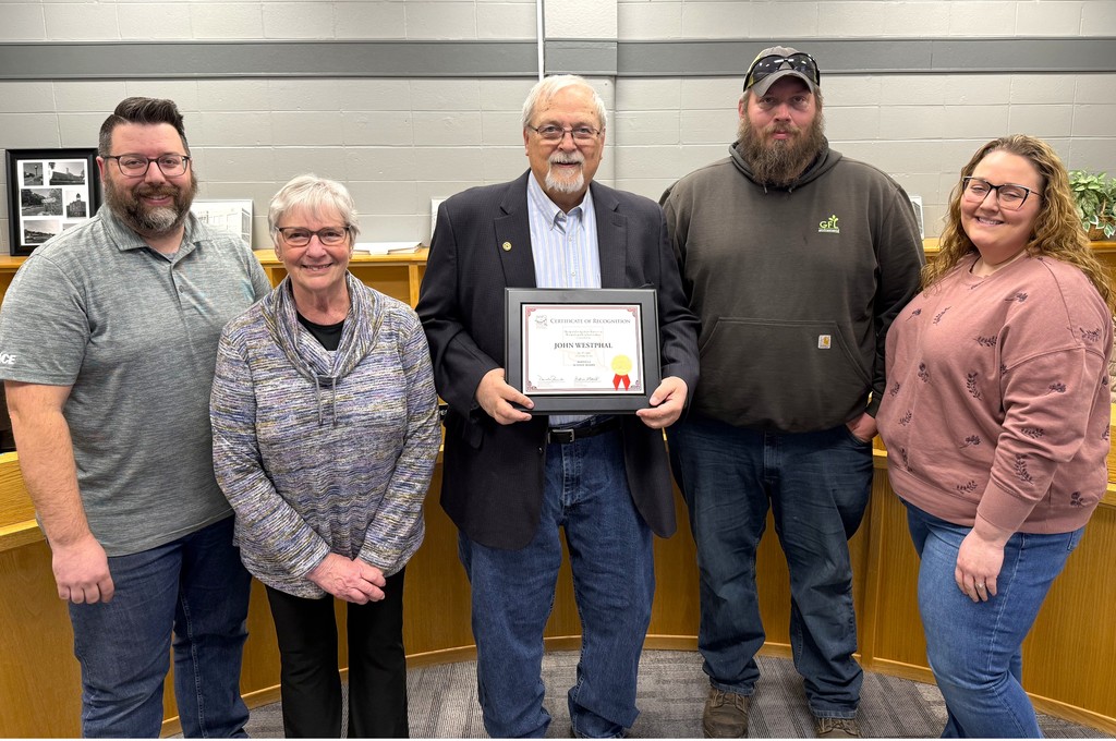 John Westphal Board Member recognition for 30 years of service, Mr. Westphal holding plaque in Board Administration Room within the Early Learning Center at Parkview, surrounded by fellow Board members, his family and presented the plaque by Dan Rossmiller, Executive Director of WASB