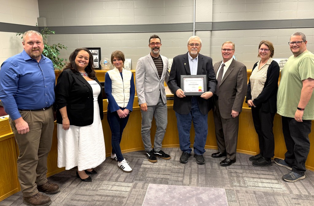 John Westphal Board Member recognition for 30 years of service, Mr. Westphal holding plaque in Board Administration Room within the Early Learning Center at Parkview, surrounded by fellow Board members, his family and presented the plaque by Dan Rossmiller, Executive Director of WASB