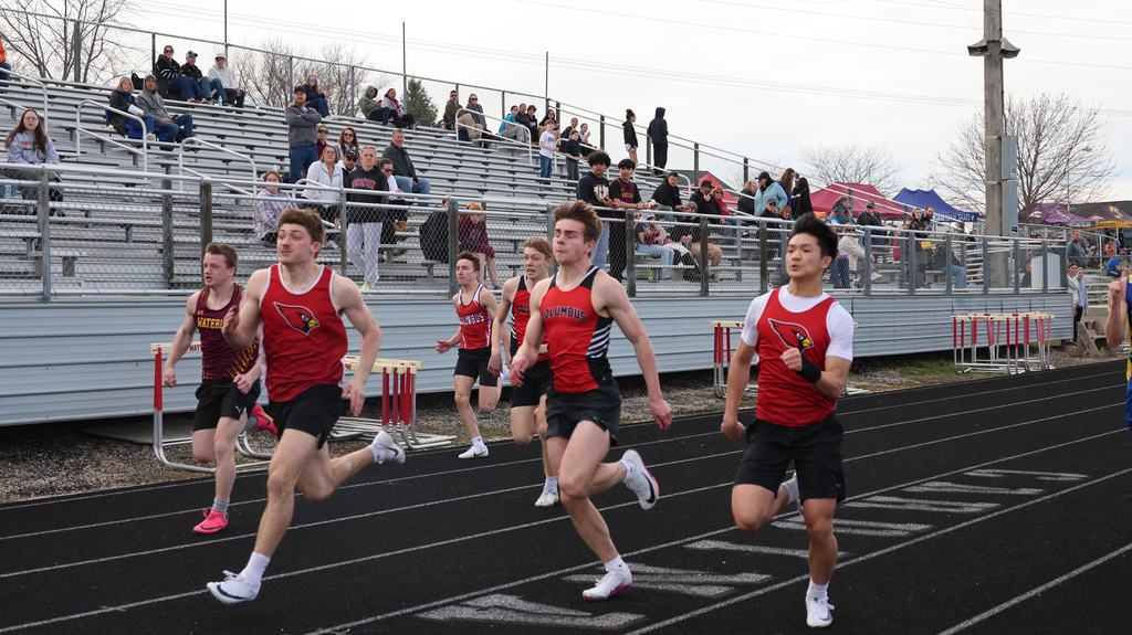 Mayville Track team Berry Invite runners on track with bleachers and fans in background