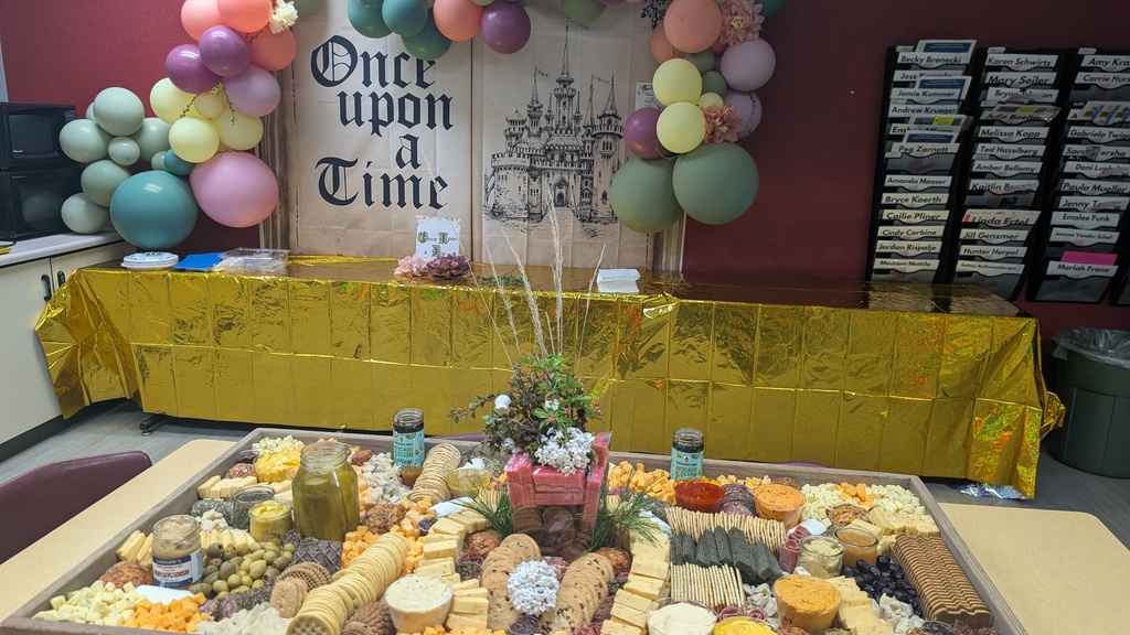 Charcuterie board with cheeses, meats, gourmet spreads and flower decor