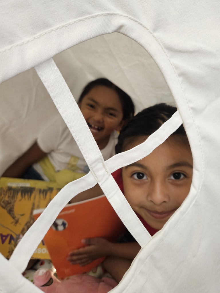 Children reading and smiling, creating reading nooks, tents and homemade lanterns