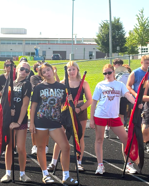 MHS Band Camp students playing instruments, practicing the halftime routine on the football field, and marching