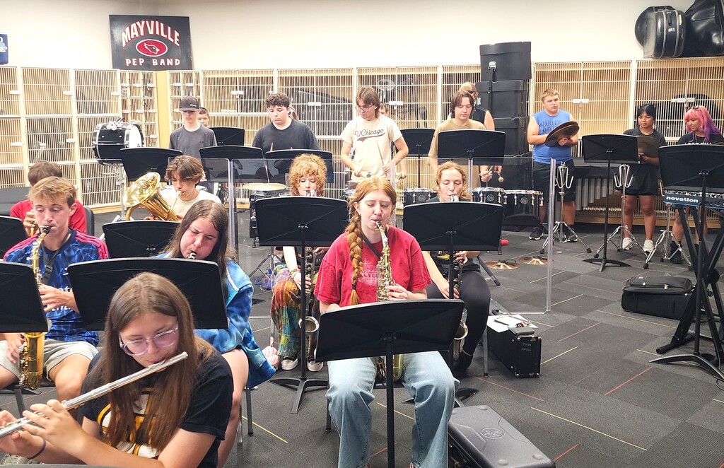 MHS Band Camp students playing instruments, practicing the halftime routine on the football field, and marching