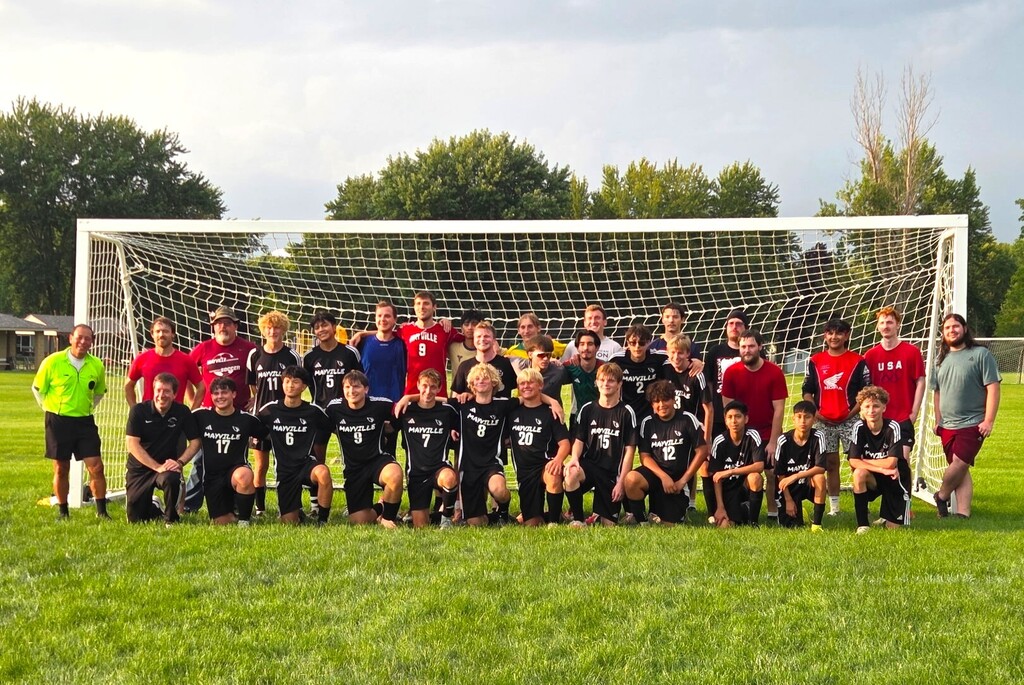 MHS boys alumni soccer game group smiling in front of soccer goal