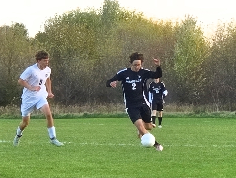 MHS Boys Soccer vs. Lake Mills at home final regular season game 10/16/26 student athletes playing on sunny soccer field with fall background