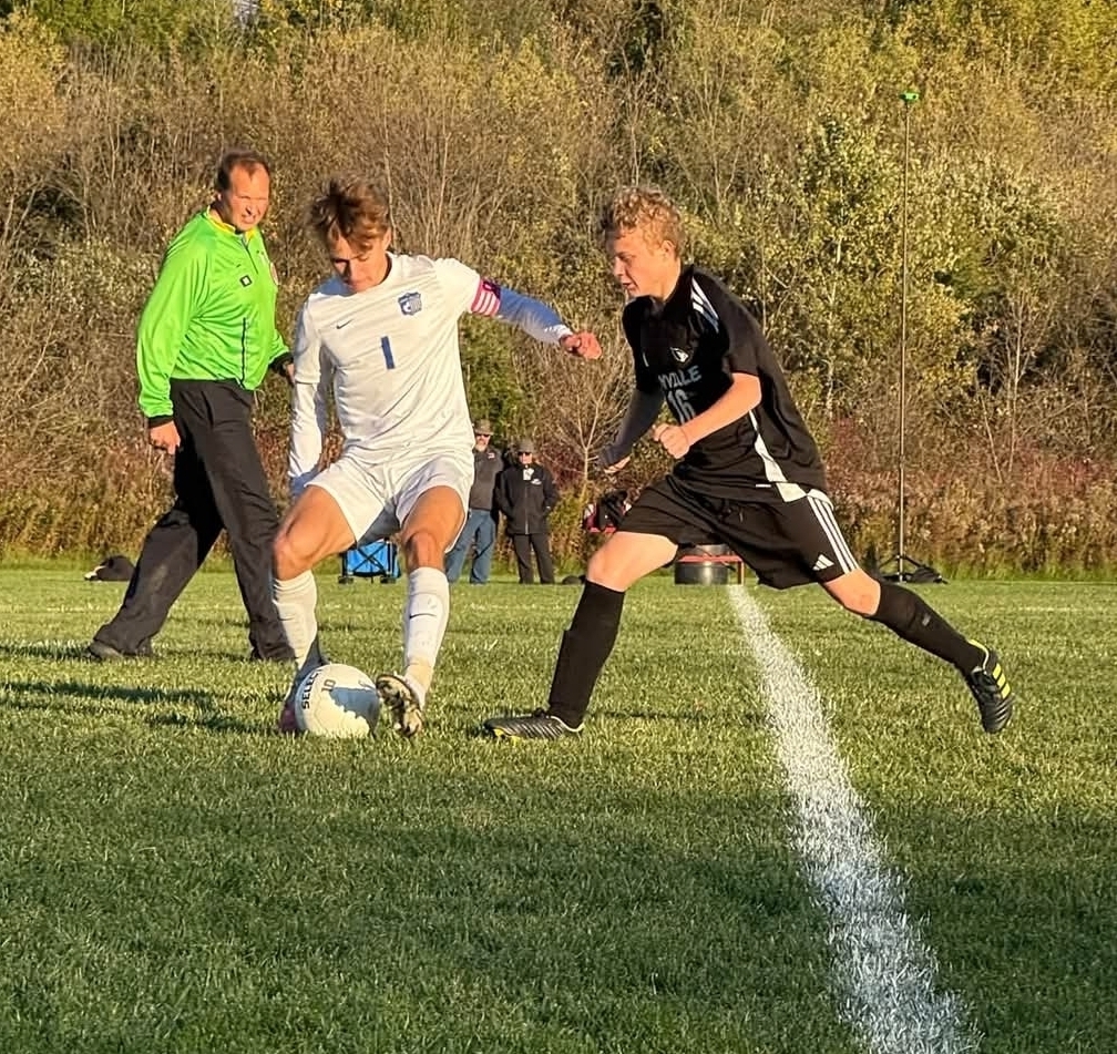 MHS Boys Soccer vs. Lake Mills at home final regular season game 10/16/26 student athletes playing on sunny soccer field with fall background