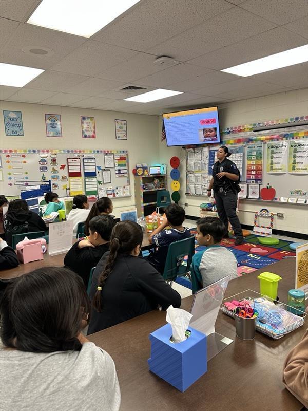 Officer presenting to students.