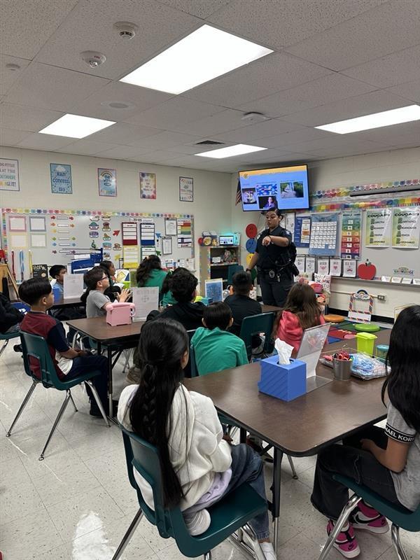 Officer presenting to students.