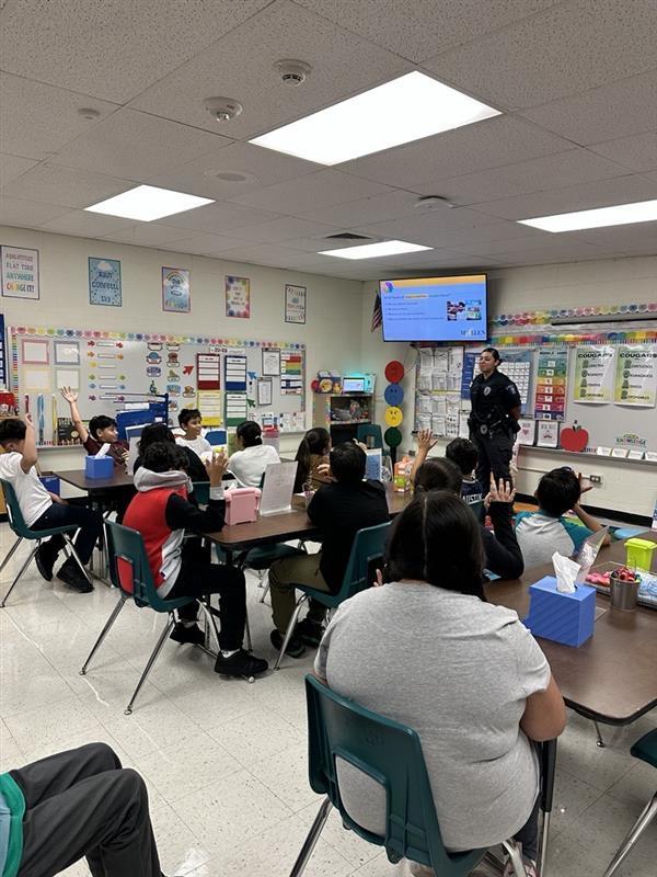 Officer presenting to students.