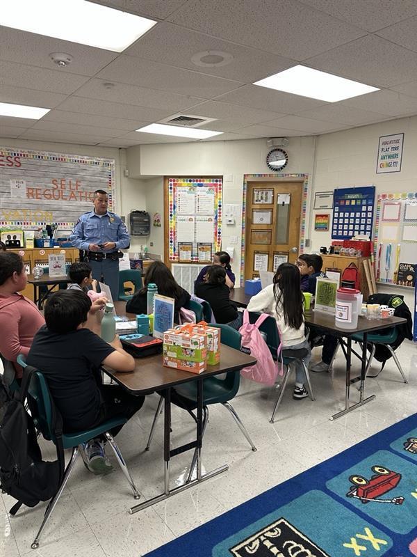 Officer presenting to students.