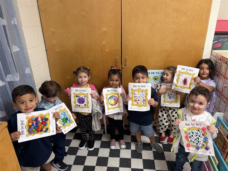 Kids posing with dot day activity.