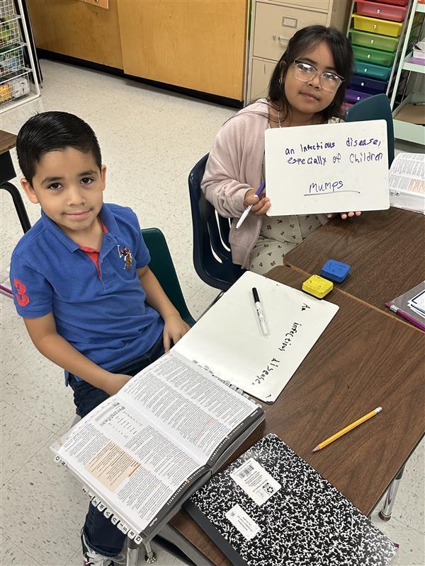 Kids posing with dictionary.