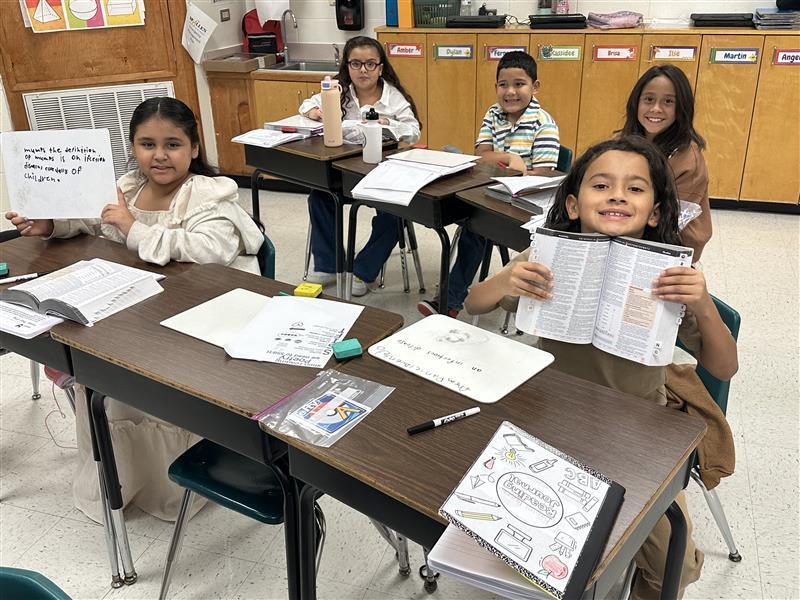 Kids posing with dictionary.