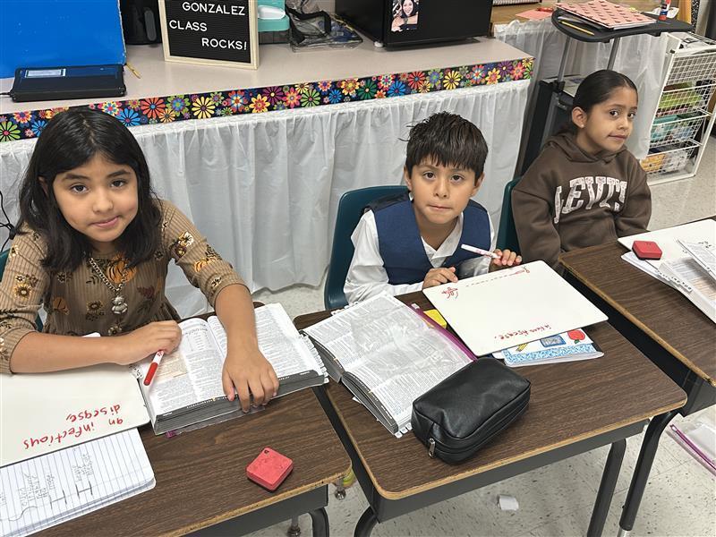 Kids posing with dictionary.