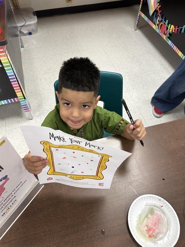 Kid posing with art activity.