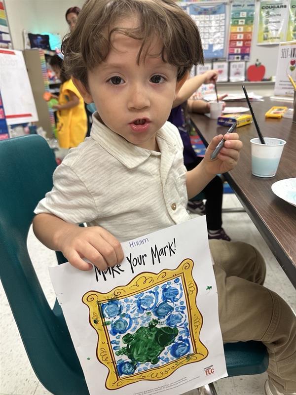 Kid posing with art activity.