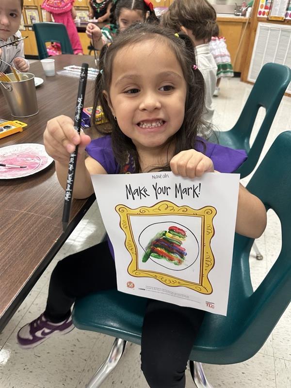 Kid posing with art activity.