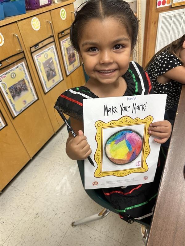 Kid posing with art activity.