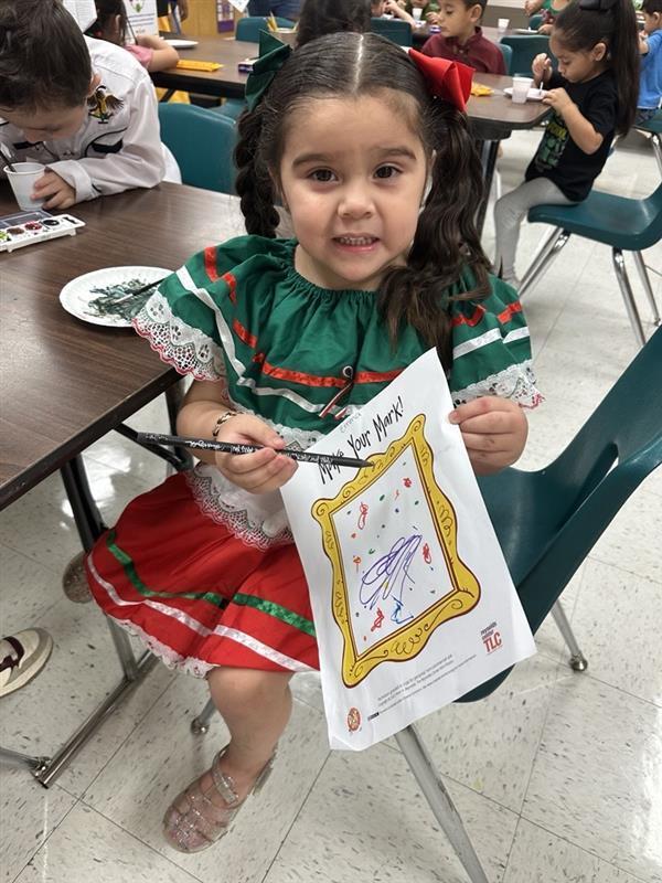 Kid posing with art activity.