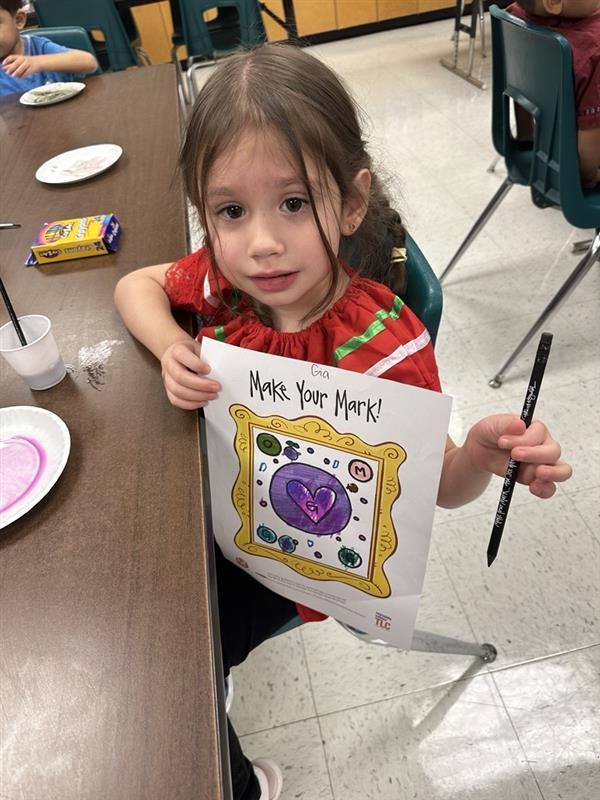 Kid posing with art activity.