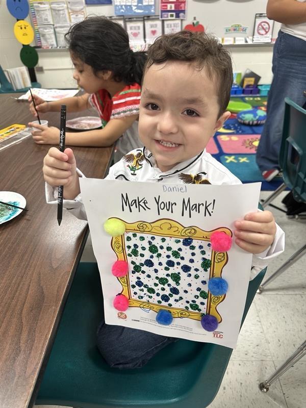 Kid posing with art activity.