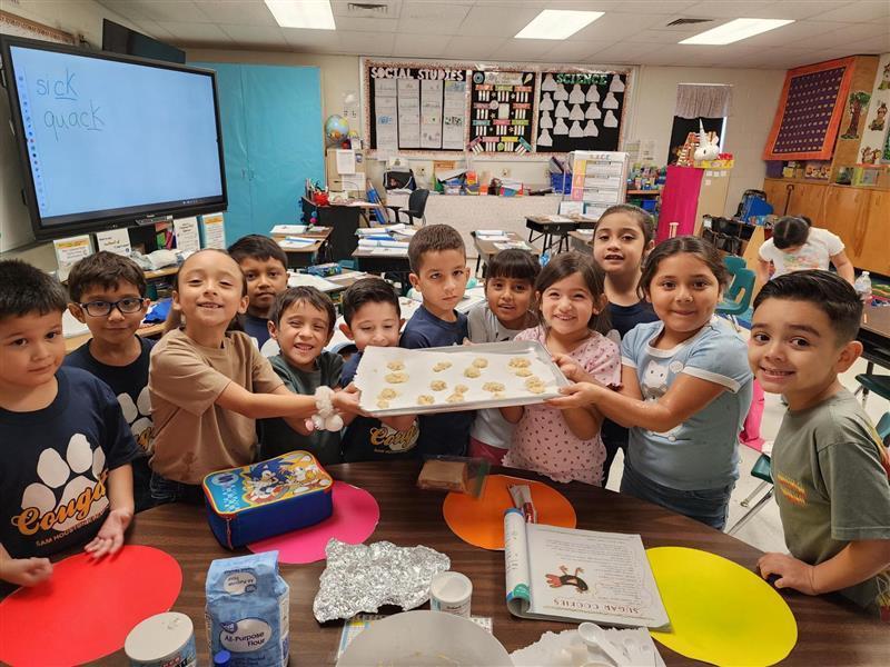 Kids posing with cookie pan.