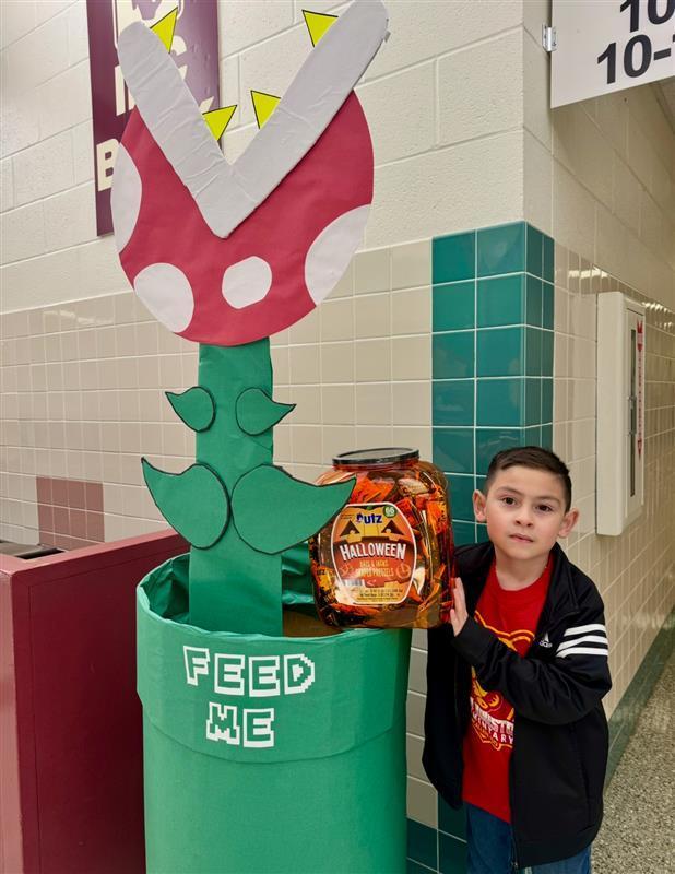 Kid posing feeding the piranha plant.