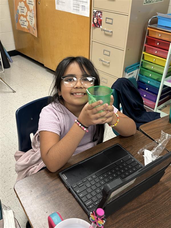 Student posing with refreshing drink.