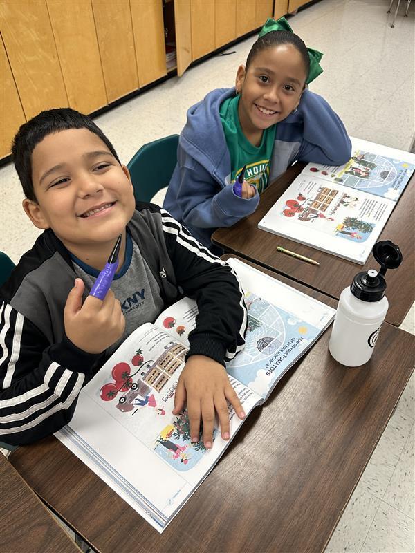 Kids reading by pointing with spooky finger.