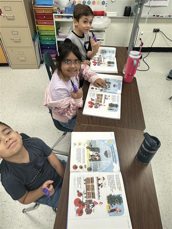 Kids reading by pointing with spooky finger.