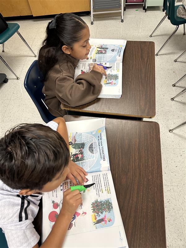 Kids reading by pointing with spooky finger.