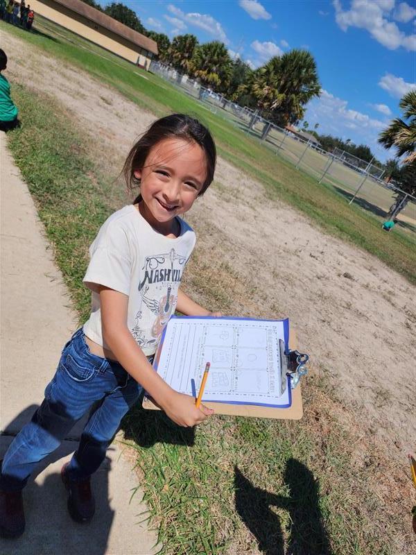 Student posing with clipboard.