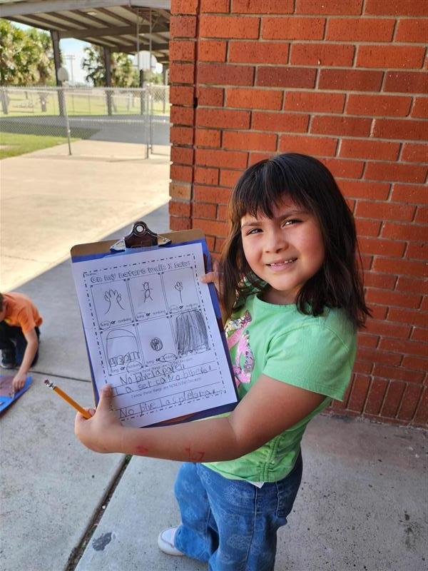 Student posing with clipboard.