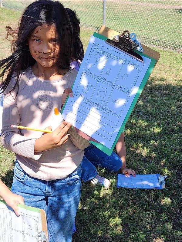 Student posing with clipboard.