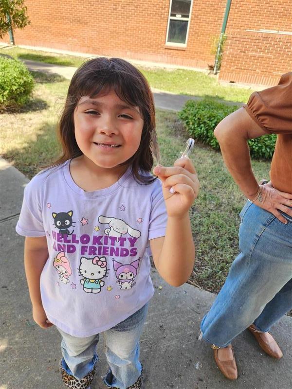 Kid posing with living thing.