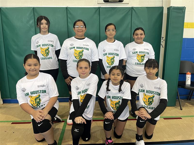 Kids posing in their volleyball attire.