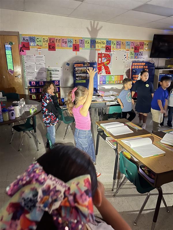 Students using a flashlight to create shadows.