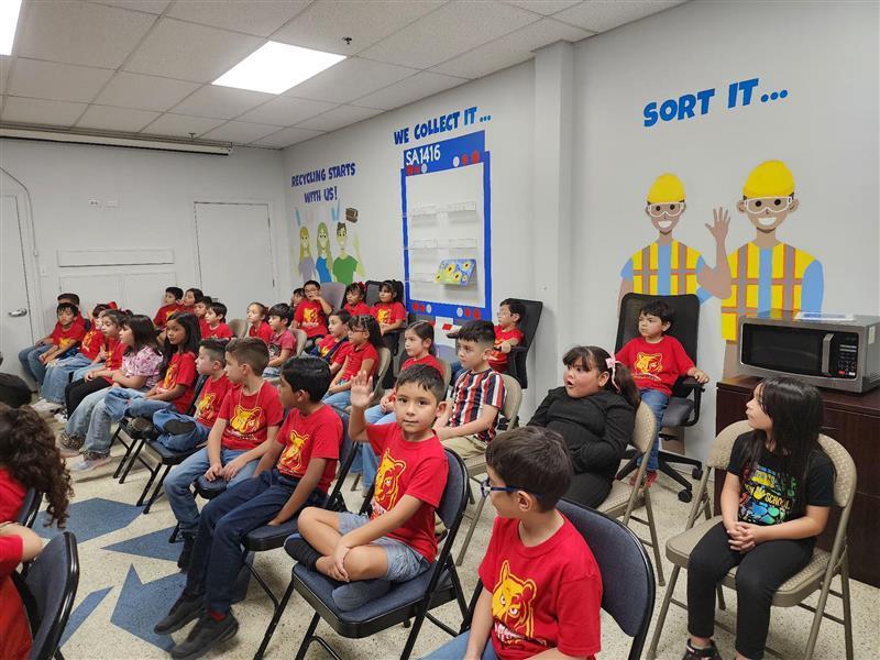 Kids posing in front of the recycling center.