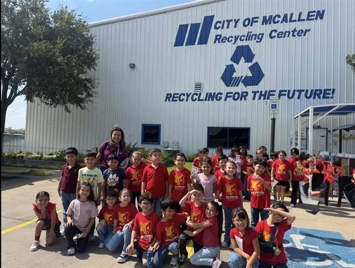 Kids posing in front of the recycling center.